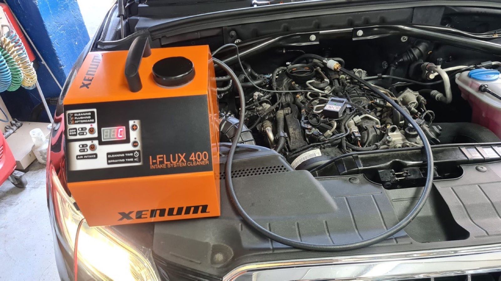 Equipo de limpieza de admisión conectado al motor de un vehículo en Garage Rodríguez