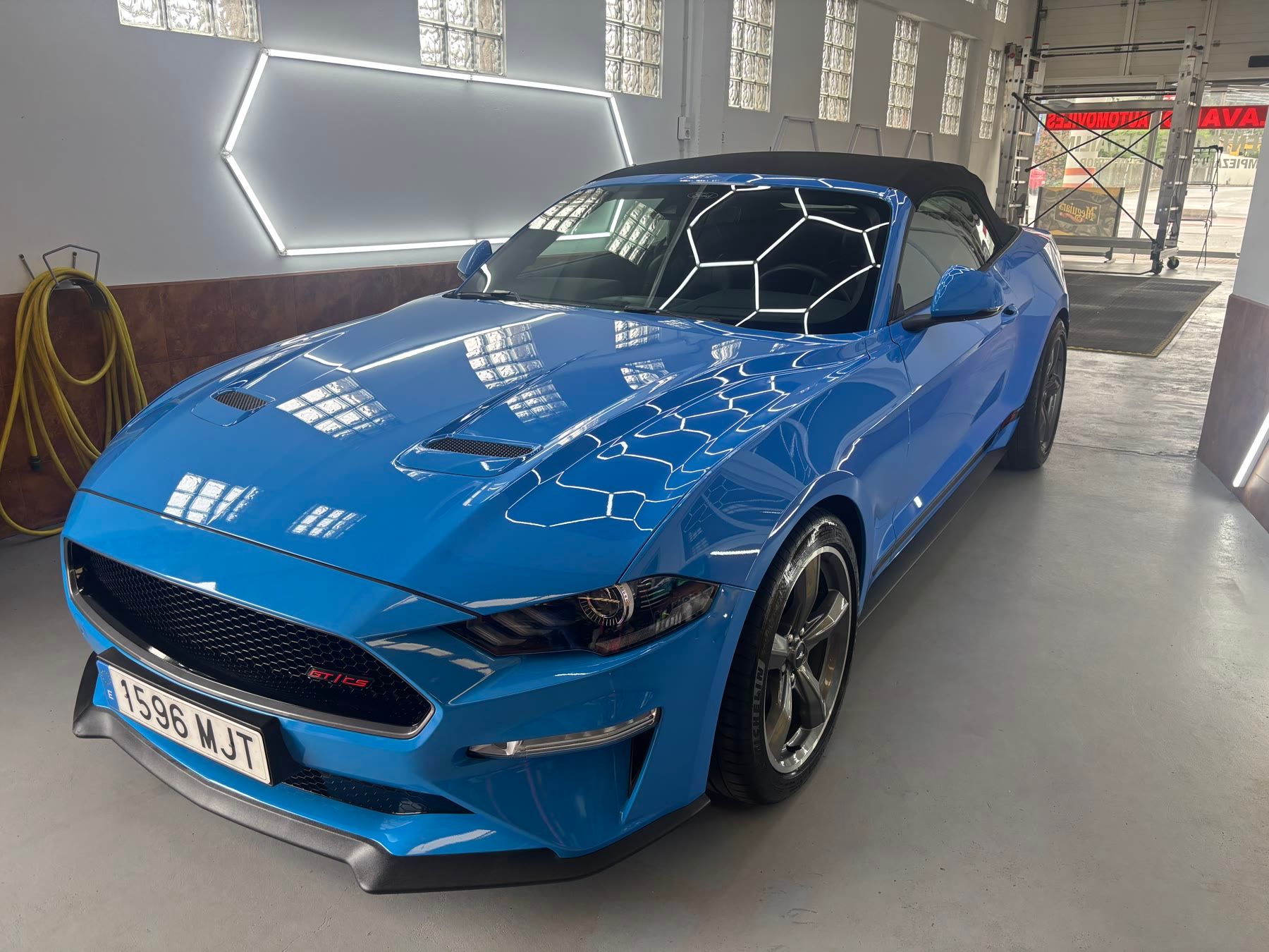 Ford Mustang descapotable azul en la zona de detailing
